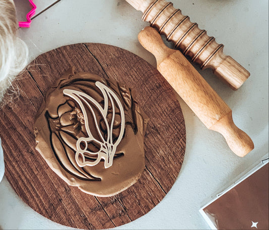 Child using Kinfolk Gumnut Leaf dough cutter with eco-friendly tools and materials on a wooden board.